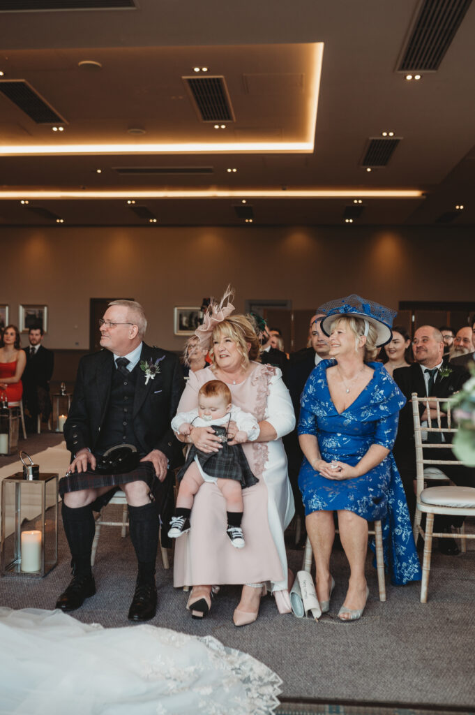 Proud parents looking on at son and daughter who are getting married at Meldrum house, aberdeenshire 