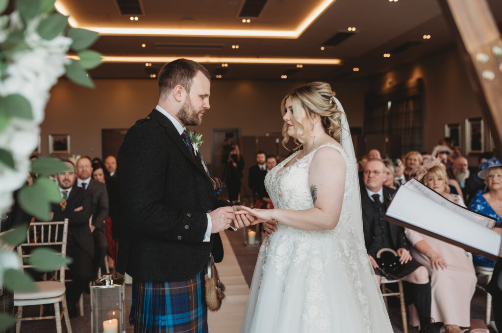 Bride and groom exchange rings at Meldrum house, aberdeenshire 