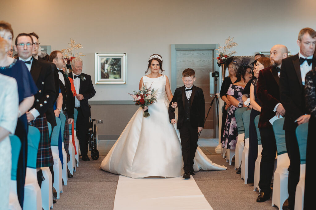 Aberdeenshire bride walks down the aisle with son during wedding ceremony at meldrum house