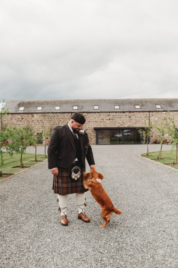 Candid moment between an Aberdeenshire groom and his dog at Schivas Steading